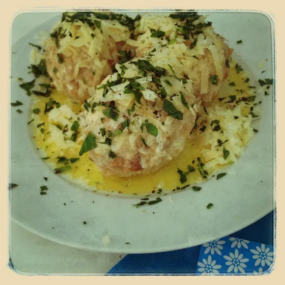 Semmelknödel mit Petersilie in heller Sauce auf einem Teller